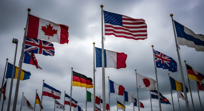 Collection of national flags flying on poles against a cloudy sky with countries
