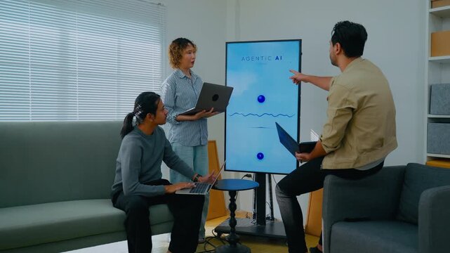 Developer team meeting for planning and developing Voice assistant and Agentic AI program. Professional software engineers using laptop and smart screen for system analytics in modern tech office