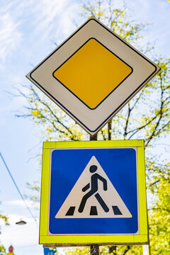 Priority road and pedestrian crossing traffic signs in a sunny city