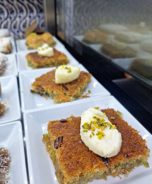 Sweet authentic shredded pastry kadayif generously topped with clotted cream on a white plate