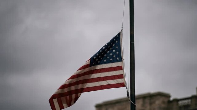 American flag waving on a flagpole against cloudy sky  