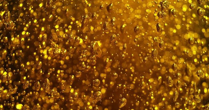 Super slow motion (1000 fps) golden bubbles rising in liquid. Champagne-like effervescence with sparkling highlights, creating luxurious abstract background and premium celebration feel.