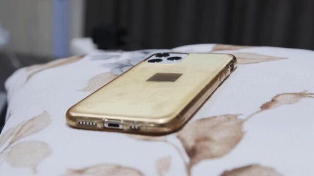 phone lying on bed surface flashing during an incoming call, close-up of modern mobile device receiving notification, communication concept, connectivity and everyday digital lifestyle