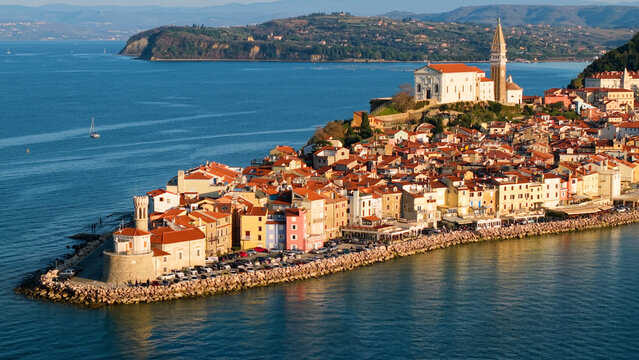 Piran Slovenia Coastal View: Venetian Towers and Historic Town Skyline in Warm Yellow Sunset Light, Medieval Peninsula and Adriatic Sea Waterfront, Mediterranean Aesthetics 4K Resolution