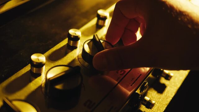 Music studio close up, Close up hands shot of sound engineer using mixing console, remote control for adjusting sound, audio mixer. Musician creates music, makes remix for DJ set. Sound recording