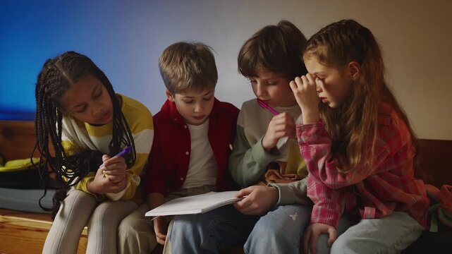 Four primary school friends doing homework together, peer learning support