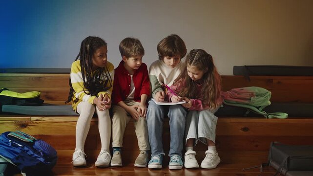 Multiracial classmates sharing ideas while working on school project together