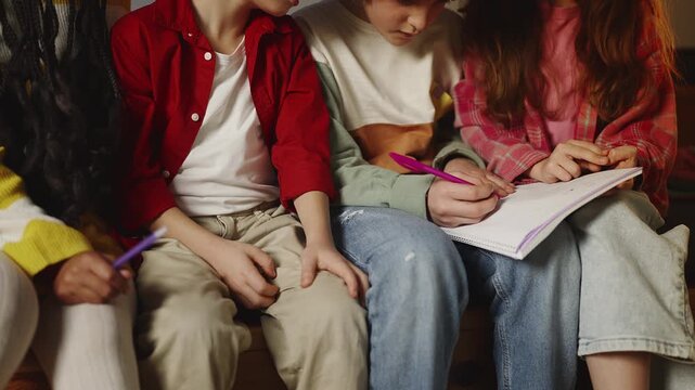 Elementary school classmates talking while doing homework, teamwork learning