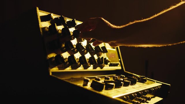 Music studio close up, Close up hands shot of sound engineer using mixing console, remote control for adjusting sound, audio mixer. Musician creates music, makes remix for DJ set. Sound recording