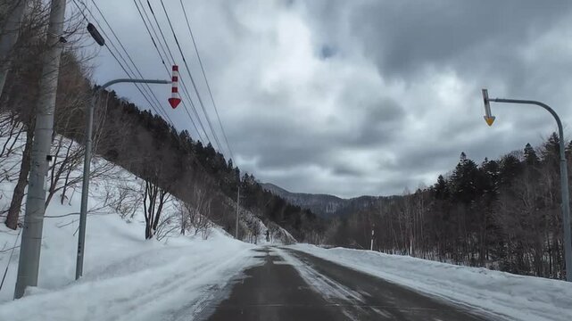 POV dashcam driving on a slippery slushy road in Furano Hokkaido Japan during winter