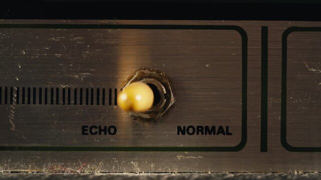 Close-up of plugging a jack into a bass guitar amplifier and turning up the volume knob, live concert show, playing music on guitar tube amplifier.
