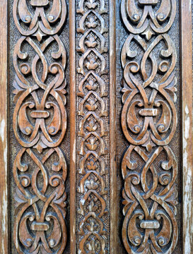 Vertical view of magnificent antique wood carving featuring symmetrical botanical decorations