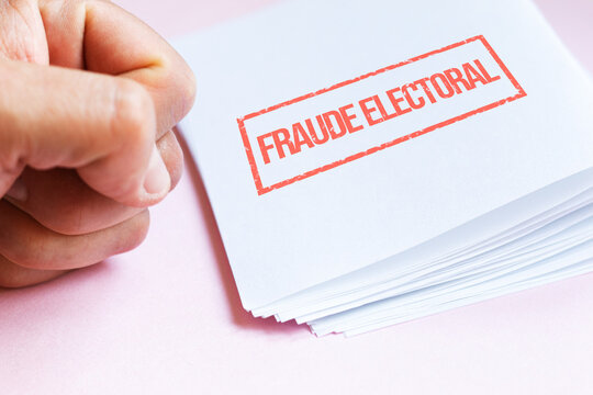 A clenched fist next to a pile of papers, an ELECTORAL FRAUD stamp in spanish on a document, denouncing irregularities in the democratic system