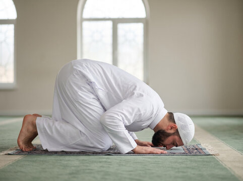 man in traditional attire performing islamic prayer in mosque during sujood showing devotion spirituality and eid religious concept