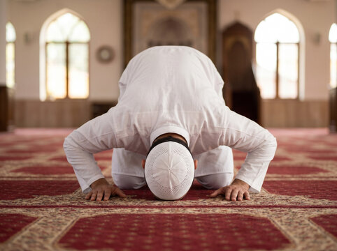 arab muslim man performing sujood prayer in mosque wearing white thobe representing faith devotion spirituality and eid celebration concept