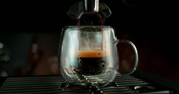 Super slow motion shot of espresso pouring into a glass cup with a slow orbital camera movement. Rich crema forms as the camera circles the cup, creating a cinematic coffee scene with depth and detail