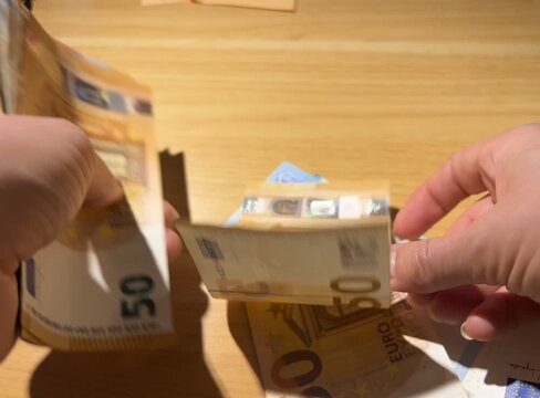 Hands counting euro banknotes