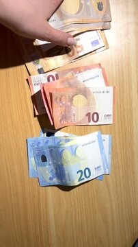 Hands counting euro banknotes
