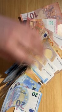 Hands counting euro banknotes