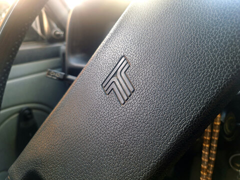 Classic interior detail showing the textured steering wheel and tofas logo of an old retro car