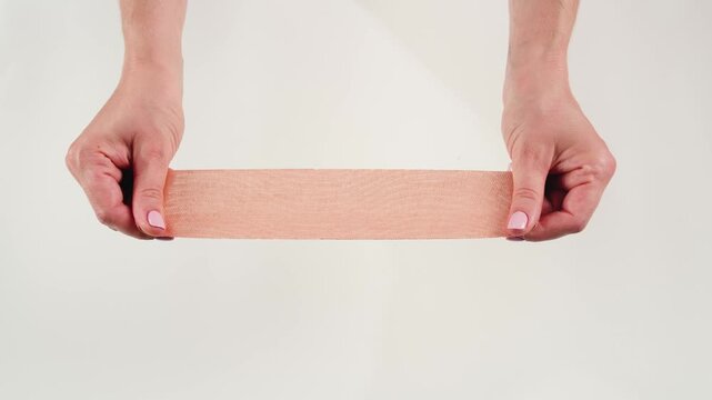 Kinesiology medical taping, doctor Physical therapist applying elastic surgical tape to patient body, treating injured knee young athlete.Post traumatic rehabilitation, sport physical therapy recovery