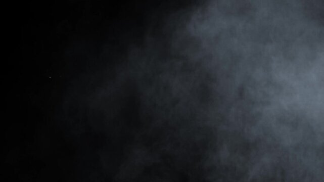 Dusty bullet hits on a wall with chunks of debris flying out . Powder explosion on black background. Impact dust particles. Dust explosion in front of black background, slow-motion close up. VFX	