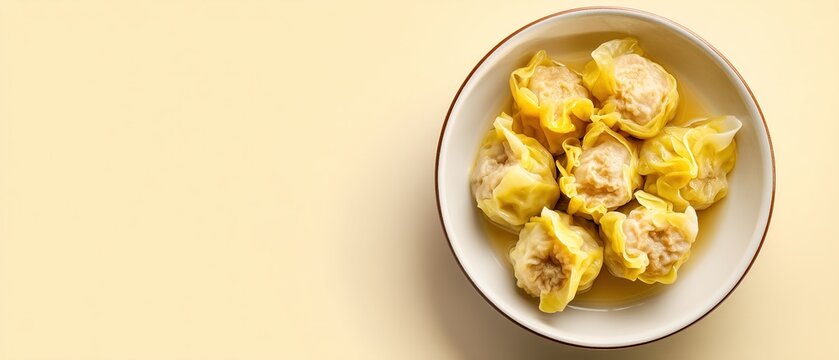 Steamed dumplings in light broth served in a bowl on neutral background