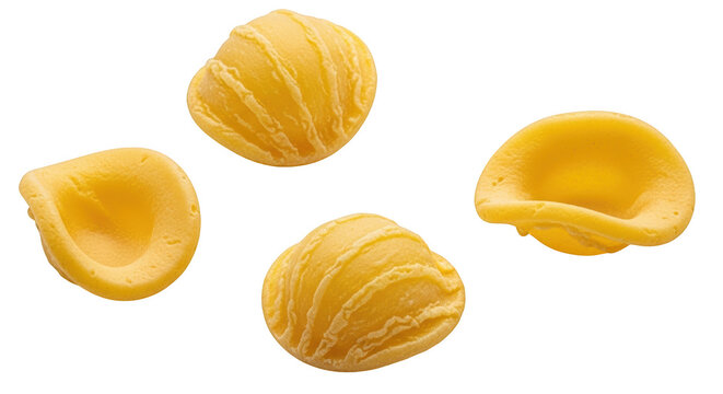 Four pieces of raw yellow orecchiette pasta with textured ridges and smooth concave shapes, isolated on transparent background