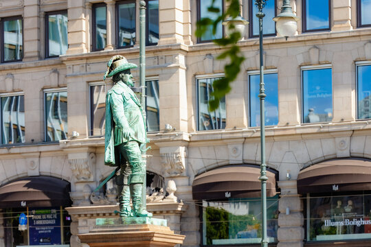 Oslo, Norway - May 17, 2025: Historic bronze statue of King Karl Johan standing in central Oslo with elegant classic buildings and city architecture in the background on a bright spring day.