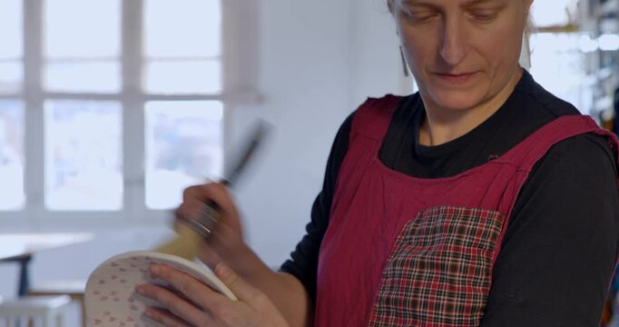 Craftswoman at Work: A skilled craftswoman meticulously shapes and refines a delicate art piece, showcasing her expertise and passion for creation.