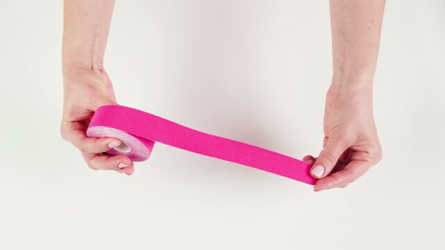 Kinesiology medical taping, doctor Physical therapist applying elastic surgical tape to patient body, treating injured knee young athlete.Post traumatic rehabilitation, sport physical therapy recovery