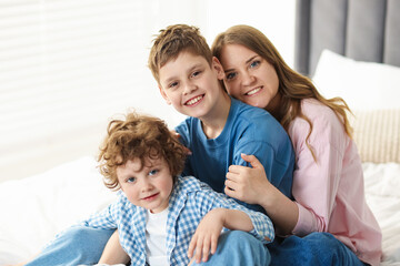 Obraz premium Portrait of mother and her sons on bed at home
