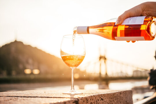 Pouring rose wine in summer sunshine during a outdoors party or a picnic.
