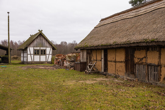 Traditional half timbered house and thatched roof barn in rural landscape, Kluki, Poland.