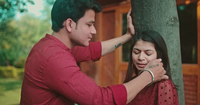 A boy gently touches the girl&rsquo;s hair as she tries to walk away, but he stops her; the couple shares an emotional eye contact in the garden. A sweet romantic interaction showing attraction, bonding