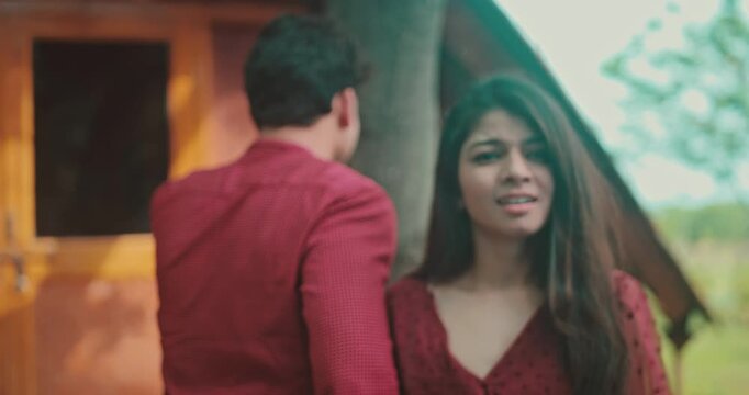 A boy gently touches the girl&rsquo;s hair as she tries to walk away, but he stops her; the couple shares an emotional eye contact in the garden. A sweet romantic interaction showing attraction, bonding