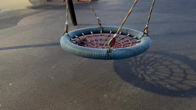 Video. A round swing on a playground is free in the evening. A rattan swing.