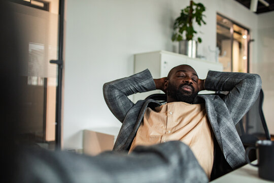 Businessman relaxing during break at modern office desk