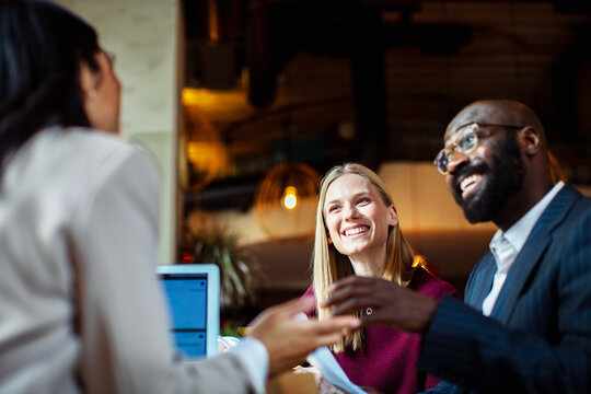 Two clients meeting with advisor in modern cafe