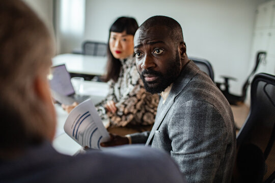 Business colleagues discussing financial report in modern office