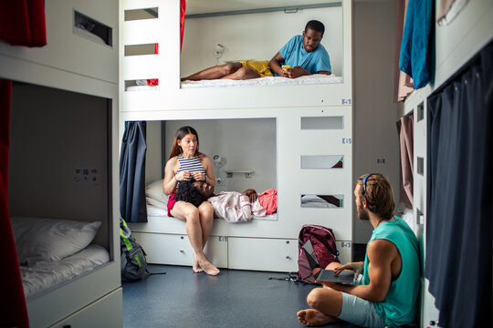 Backpackers relaxing in a modern hostel dorm