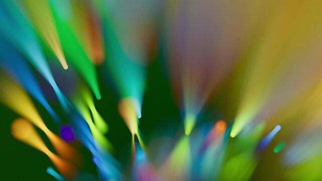 A smooth, out-of-focus spiral of rainbow colors spins continuously. The blurred textures make the colors look soft and painterly. 3D render motion.