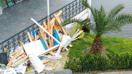 Obraz premium Pile of construction debris near palm tree by waterfront area