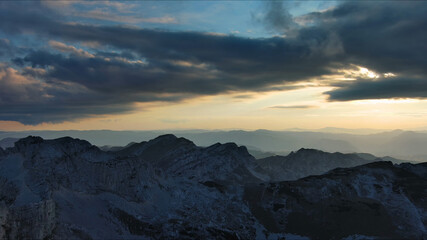 Obraz premium Sunset over mountain with dramatic clouds