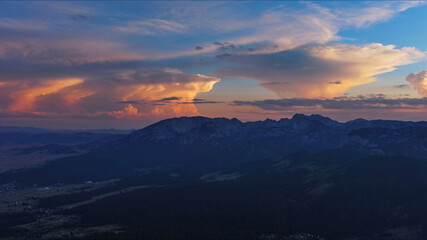 Obraz premium Sun setting over mountain and evening sky