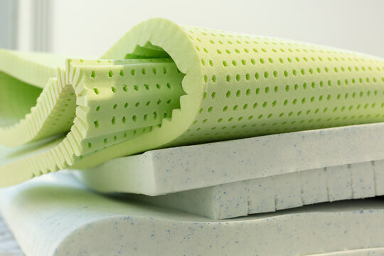 Close-up of folded latex foam layer used in mattresses and toppers. Shows material thickness, elasticity, texture, and structural flexibility for bedding systems.