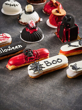 The image features an array of Halloween-themed pastries decorated with spooky elements like ghosts, spiders, and blood