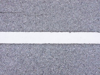 Fototapeta premium Close-Up View of Asphalt Road Surface with White Line Marking