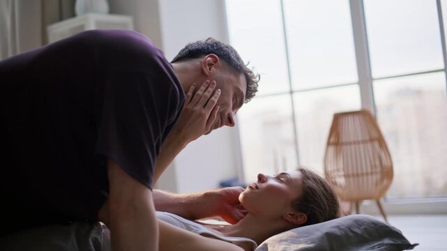 Closeup bedding pair kissing at morning lying soft pillows. Woman man touching