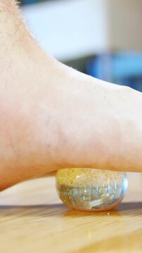 Flat feet massage with small ball close-up slow motion